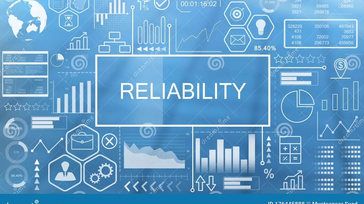 A woman smiling while working on a laptop at a desk.